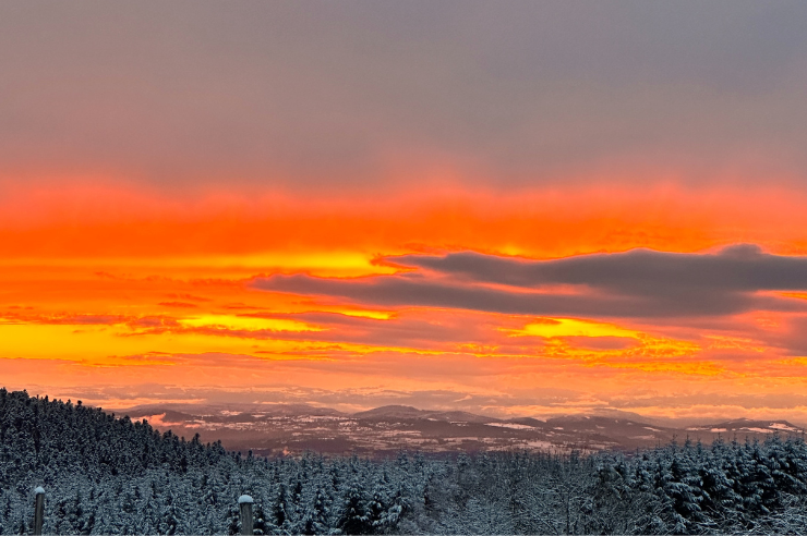 Coucher de soleil flamboyant sur Vollore-Montagne en hiver, panorama du Parc Livradois-Forez en Auvergne.