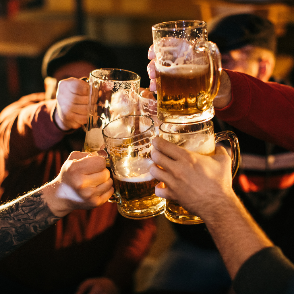 Clients trinquant avec des chopes de bière au bar de l’Hôtel des Touristes à Vollore-Montagne